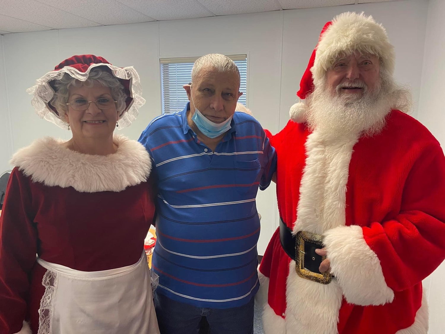 Kiwanis Club member Jerry Rapp with Mrs. Claus and Santa at the Wood County Co-op Christmas party last year.